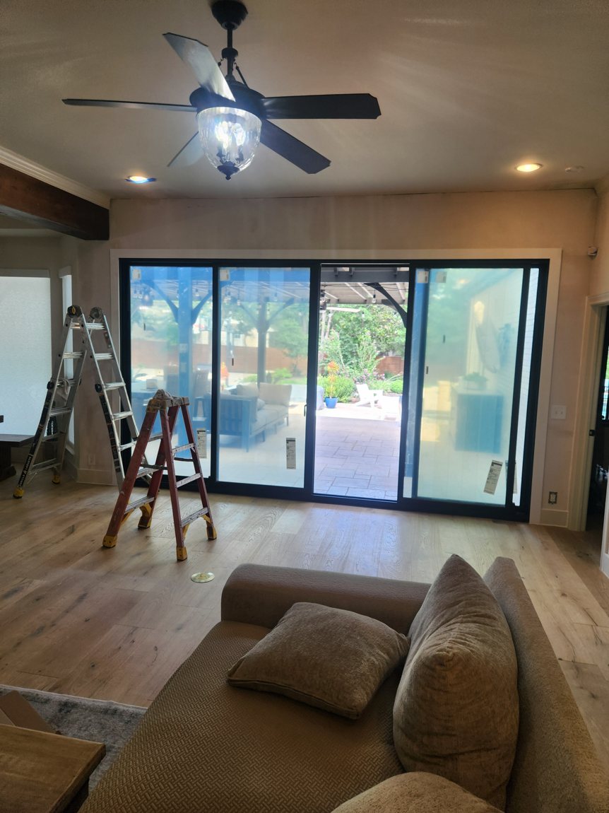 Multi-panel sliding door on install day at a real Spirit of Texas job — labels still on the glass, frames set square before sealing.